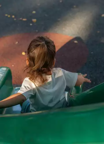 Un enfant qui descend d'un tobboggan dans une aire de jeux à Biscarrosse